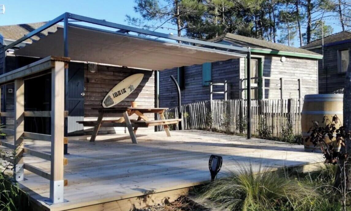 Une maison en bois avec un porche couvert et une table de pique-nique.