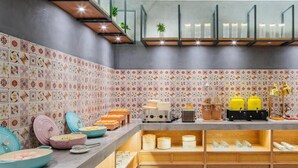 Una cocina con salpicadero de azulejos, repisas de madera y diversos electrodomésticos.