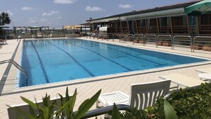A swimming pool with tiled deck, sun loungers, and a covered seating area. - Julia House (Viareggio)