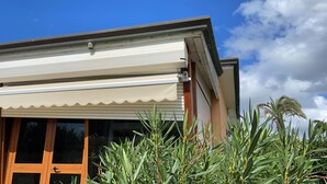 A modern building with a white awning, large windows, and a view of palm trees. - Julia House (Viareggio)