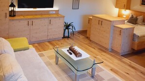 A modern living room with a flat-screen TV, wooden cabinets, a glass coffee table, and a cozy seating area. - Cozy vacation apartment between Moselle and Rhine, near various dream loops and castles (Brodenbach)