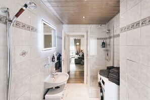 Bathtub, hair dryer, towels, toilet paper