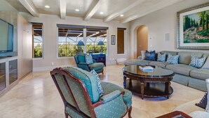 A spacious living room with a large window, a sofa set, a coffee table, and a television. - Southern Charm Close To Beach (Marco Island)