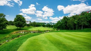 A well-manicured golf course with rolling hills, trees, and a clear blue sky. - Queen Suite Near Hwy 76 • Close to Shows • Sleeps 2 (Branson)