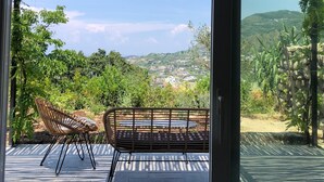 A patio with a table and two chairs, a pergola, and a view of a hilly landscape. - new Apartment - Ischia Garden Suites (Forio)
