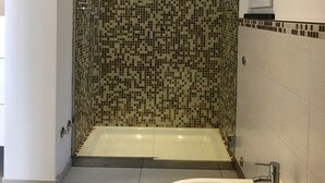 A bathroom with a mosaic-tiled shower wall, a bathtub, and a sink with a mirror above it. - new Apartment - Ischia Garden Suites (Forio)