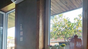 A bedroom with a bed, a window with a view of a tree, and a potted plant on the windowsill. - Ruby Charm Houses 9 116352/AL (Porto)