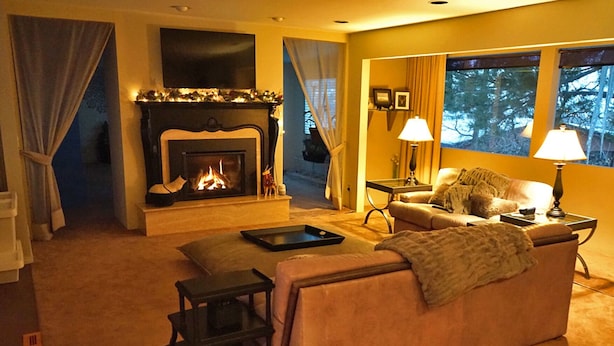 Una sala de estar acogedora con chimenea, un sofá, una mesita de centro y dos lámparas.