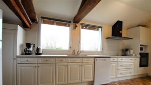 A kitchen with white cabinets, a dishwasher, a coffee maker, and a microwave. - Chez Laborde - Riupeyrous (RIUPEYROUS)