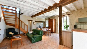 A spacious living area with a green sofa, wooden coffee table, and a staircase. - Chez Evon - Jurancon (JURANCON)