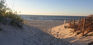 Uma praia arenosa com vista clara para o oceano.
