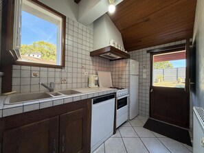 Una cocina compacta con lavabo, estufa y refrigerador.