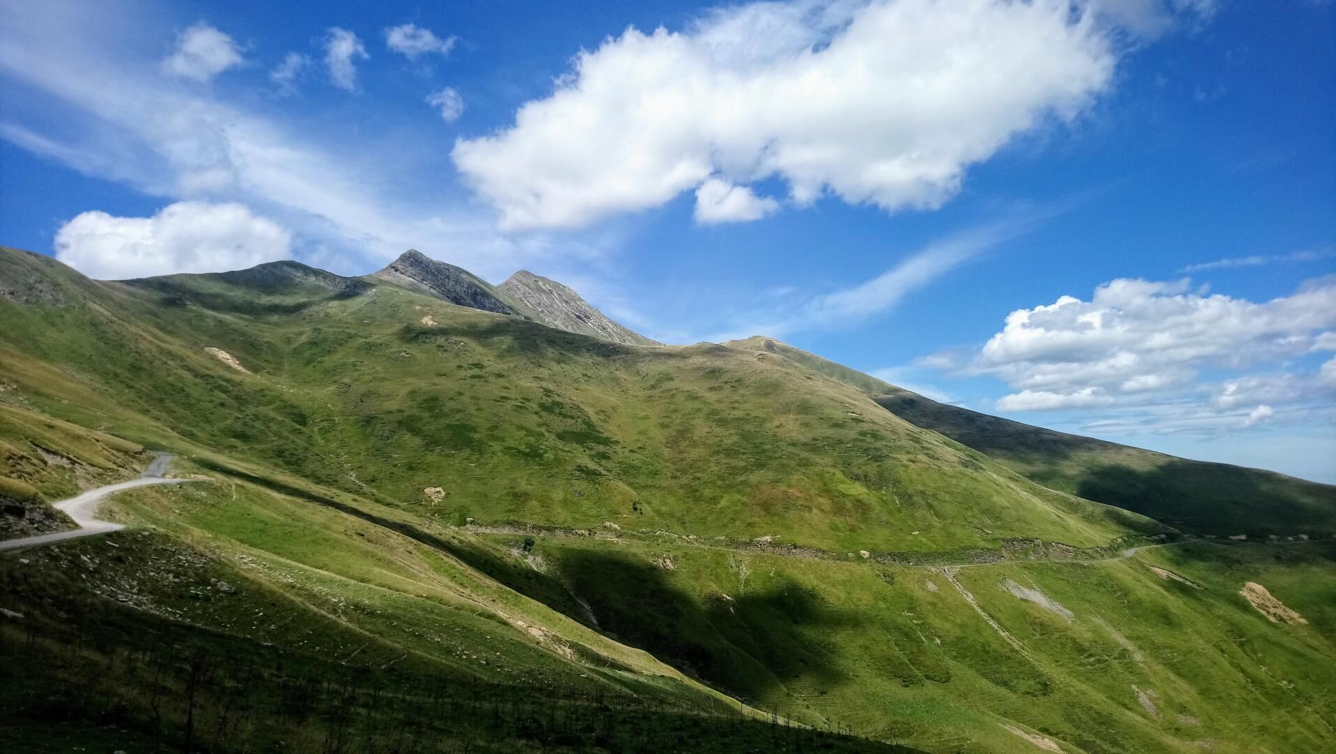 A mountainous landscape with a winding road and a clear sky.