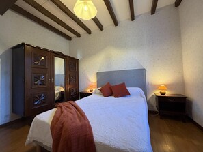 Une chambre à coucher avec un lit, une armoire en bois et deux lampes de chevet.