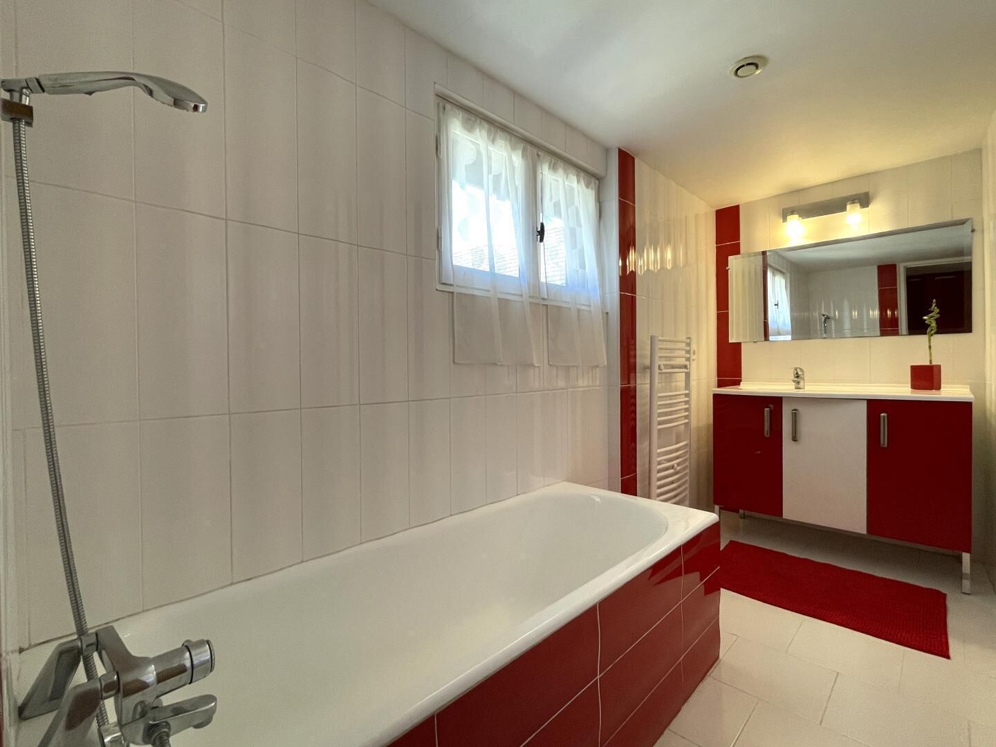 A modern bathroom with a freestanding bathtub, a shower, and a vanity with a mirror.