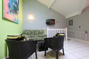 Relax in this inviting living area with a sofa, two chairs, and a flat-screen TV.