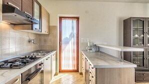 A modern kitchen with a gas stove, stainless steel sink, and wooden cabinets.