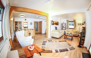 Relax in this airy living space with a sofa, coffee table, and dining area.