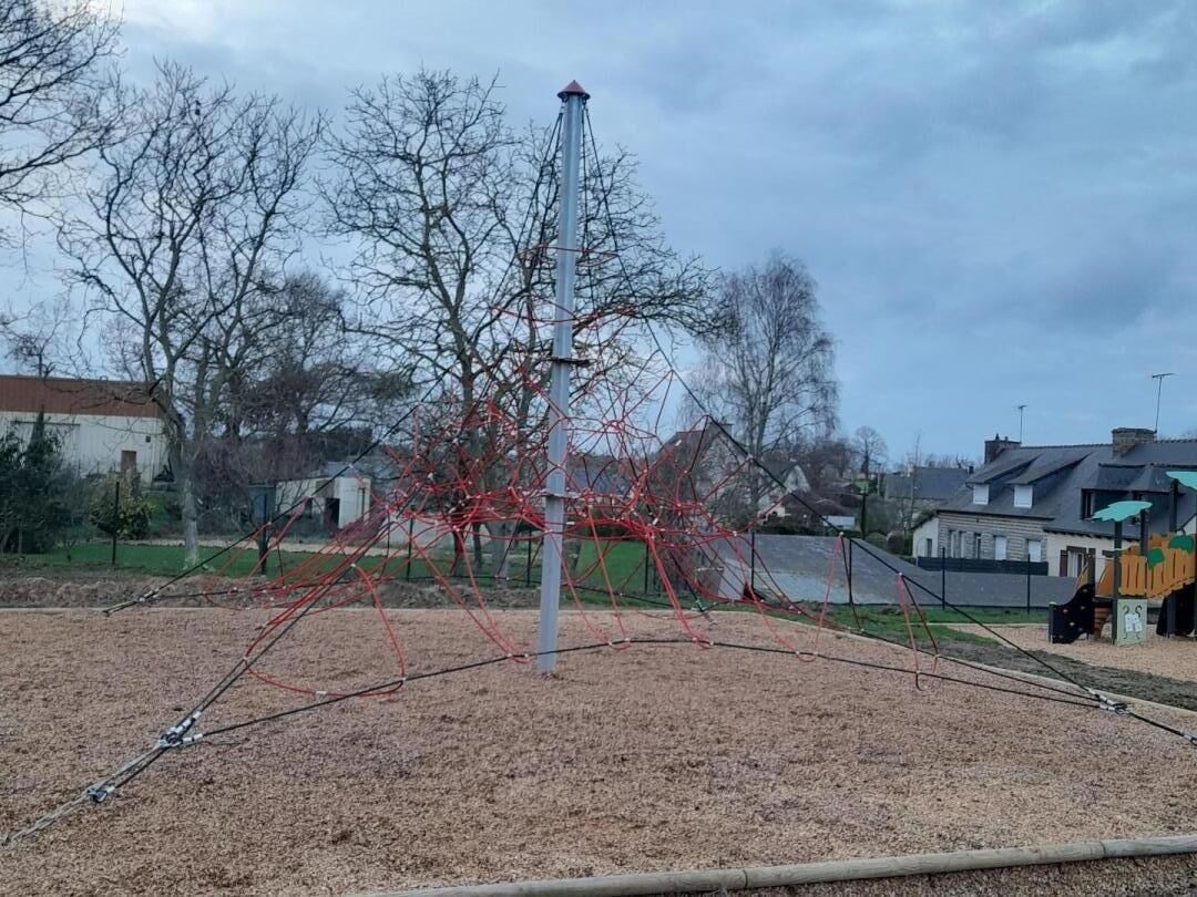 Ein Spielplatz mit einer Kletterkonstruktion und einem hohen Kletterstange.