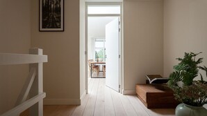 A hallway with a wooden floor leading to a dining area with natural light. - Awesome home in Bergen aan Zee (Bergen aan Zee)