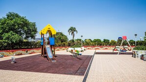 A playground with a slide, swings, and a climbing structure. - Gorgeous apartment in Cabanes with swimming pool (Cabanes)