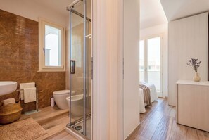 Ein modernes Badezimmer mit Duschkabine aus Glas, einem großen Waschbecken und einer Toilette.