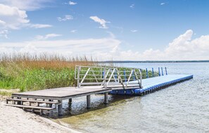A wooden pier extending into a body of water, with a metal railing and steps leading to a dock. - 2 bedroom beautiful home in Nowe Warpno (Nowe Warpno)
