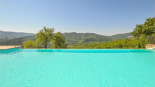 A clear blue infinity pool with a view of green hills and mountains in the background. - Gorgeous home in Arezzo (Arezzo)