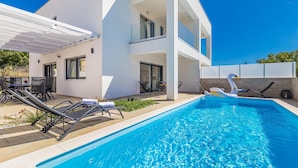 A modern two-story building with a swimming pool, outdoor seating, and a swan float. - Cozy home in Linardici (Linardici)