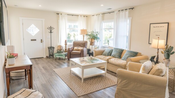 Un salon comprenant un canapé, un fauteuil, une table basse et une porte ornée d’un panneau de verre décoratif.