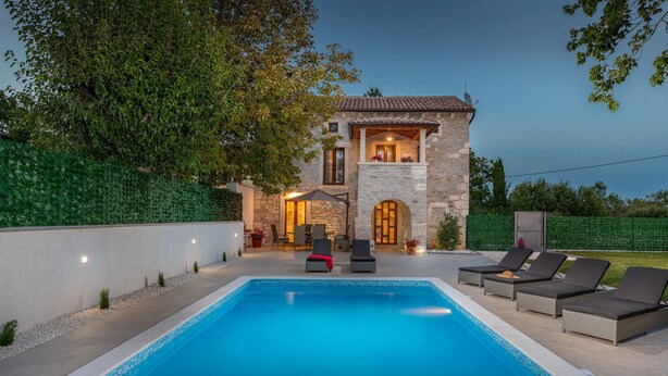 A swimming pool with lounge chairs and a stone building with a balcony. - Beautiful home in Rojnici (Rojnici)