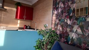 A modern kitchen with wooden cabinets, a red cabinet, a sink, and a stove. - Stockton Moors (Stockton-on-Tees)