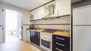 A modern kitchen with a built-in oven, a stainless steel sink, and a refrigerator. - Gorgeous apartment in Oropesa del Mar with sauna (Oropesa del Mar)