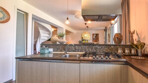 Une cuisine moderne dotée d’un îlot central, d’une cuisinière encastrée et d’un évier.