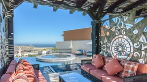 Eine Dachterrasse mit Sitzgelegenheit, einem Whirlpool und einer Zierwand.