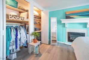A bedroom with a bed, a fireplace, a closet with clothes, and a painting on the wall. - Private Dock, Private Pool & Bayfront Paradise (Middle Township)