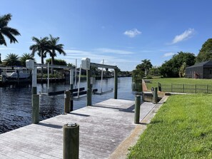A wooden dock extending into calm water with a clear sky above.