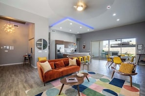 A modern living room with a sofa, coffee table, and colorful rug.