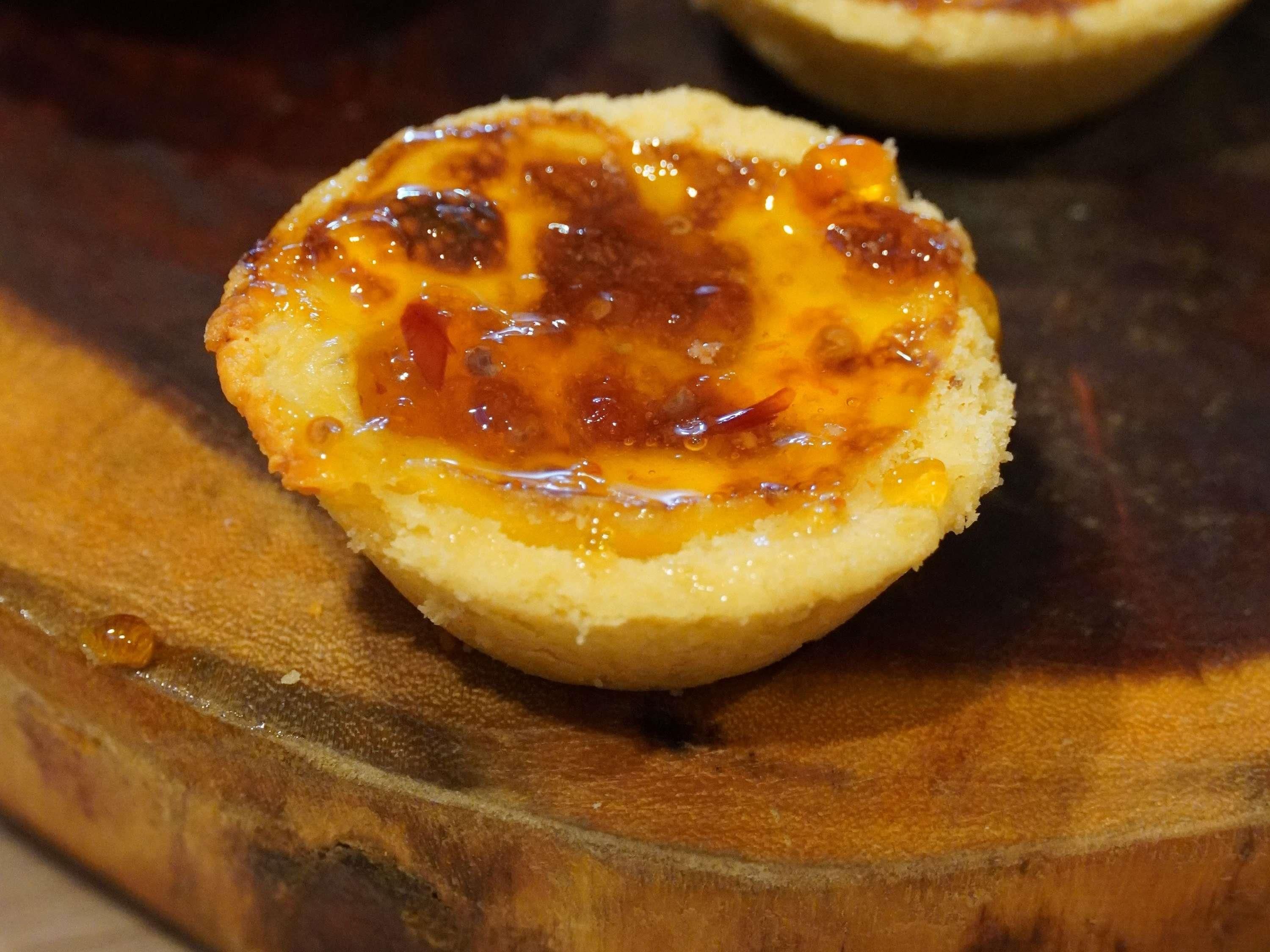 A close-up of a food item, likely a dessert, on a wooden surface.