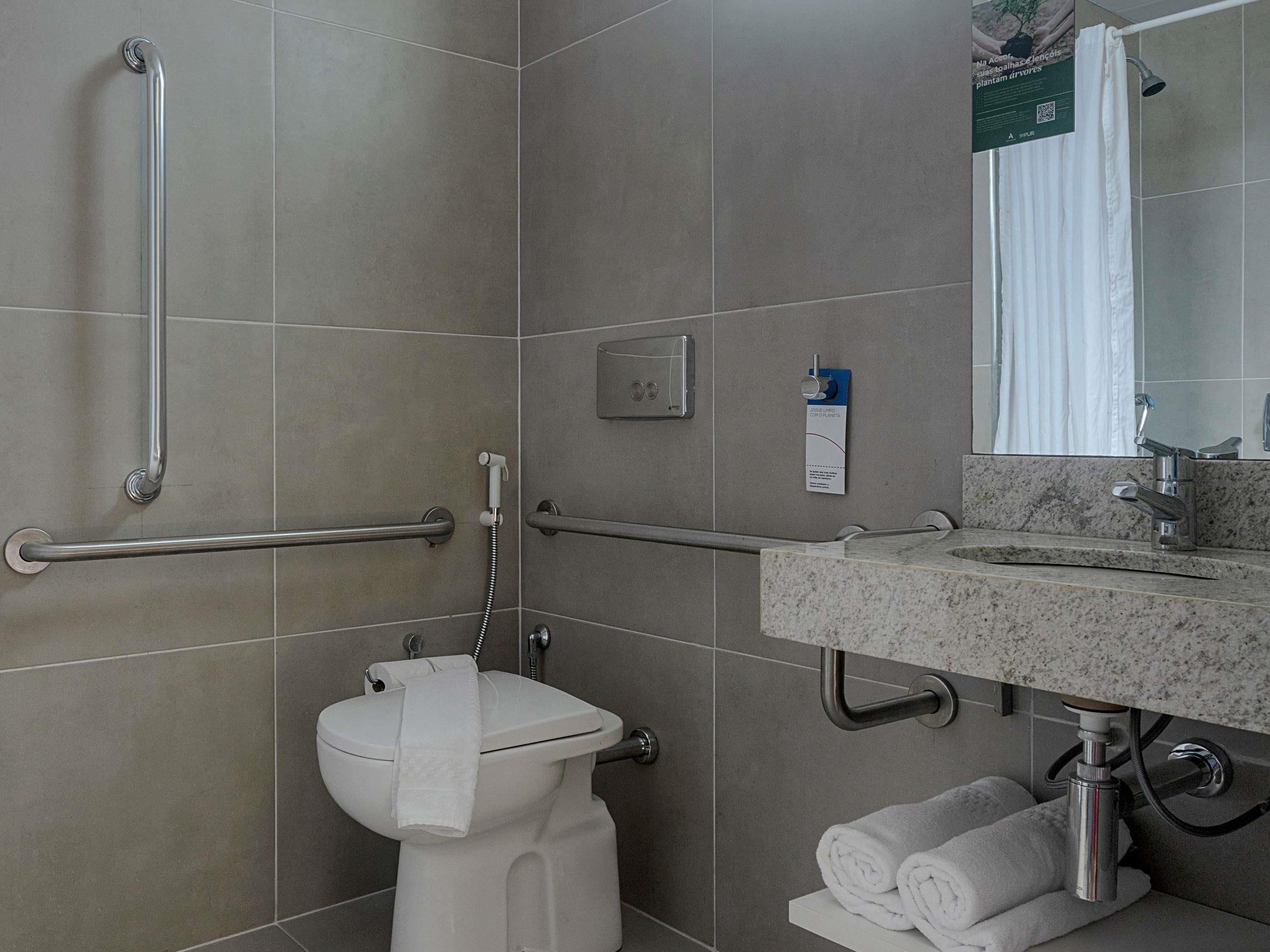 Une salle de bain comprenant des toilettes, un lavabo et un espace douche.