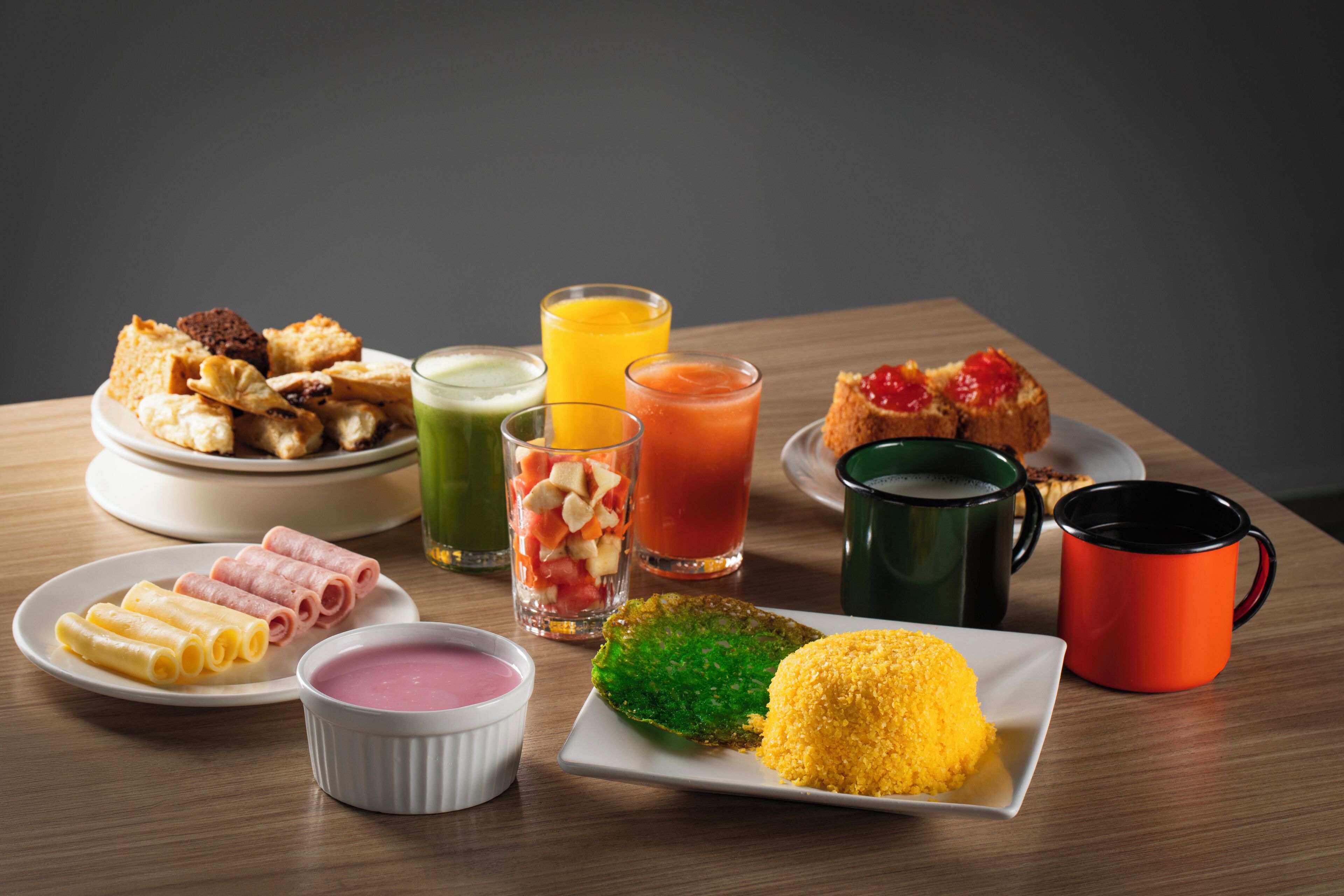 A breakfast table with various food items and drinks.