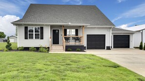 A single-story house with a front porch, a garage, and a well-maintained lawn.