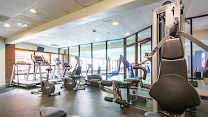 A gym with treadmills, elliptical machines, and weight benches.