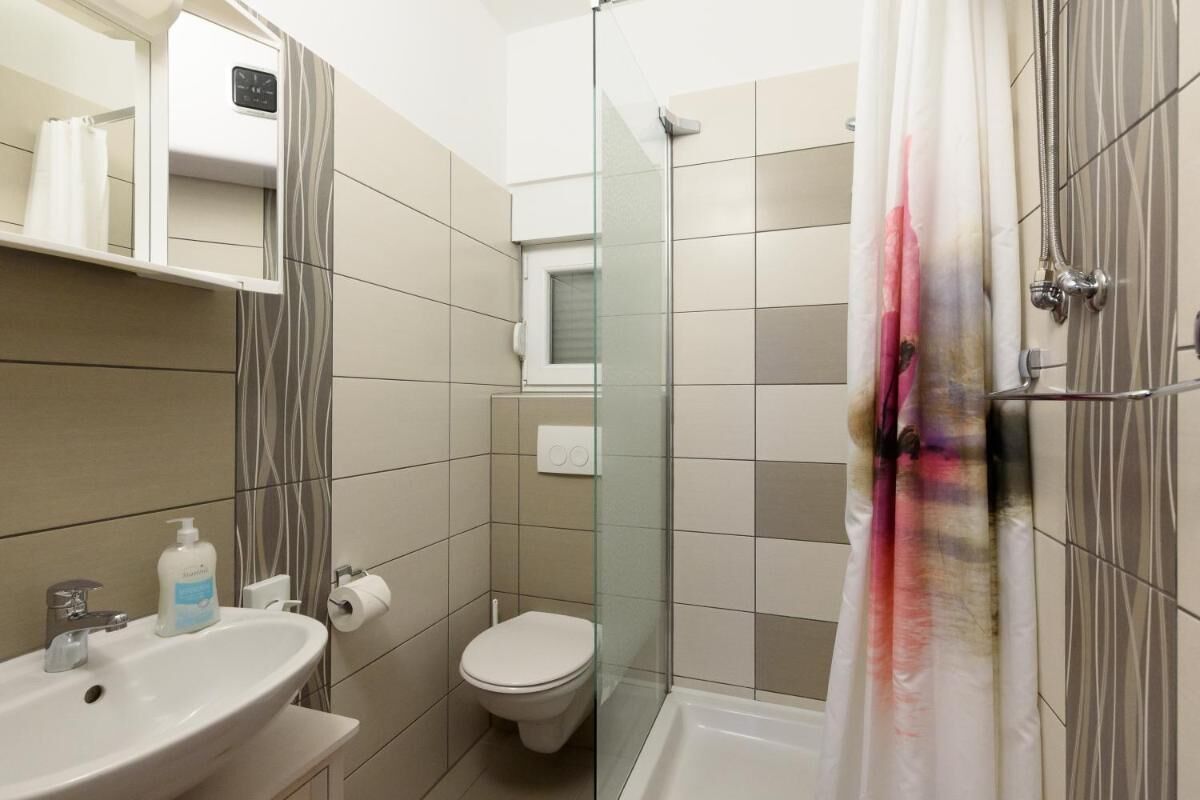 A bathroom with a sink, toilet, and shower.
