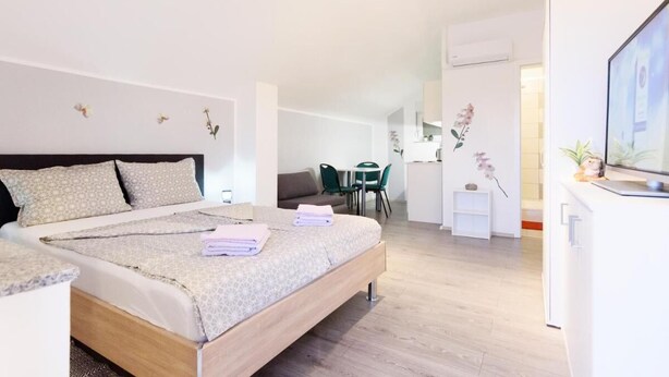 Una habitación de hotel moderna con una cama grande, un escritorio y una zona de comedor.