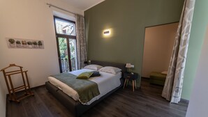 Une chambre à coucher avec un lit, une table de chevet et une fenêtre.