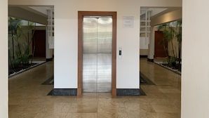 An elevator in a hallway with a sign above it. - Peace In The Village, Punta Cana Village (Punta Cana)