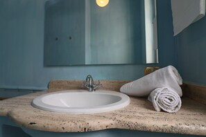 A bathroom with a sink, a mirror, and a towel.