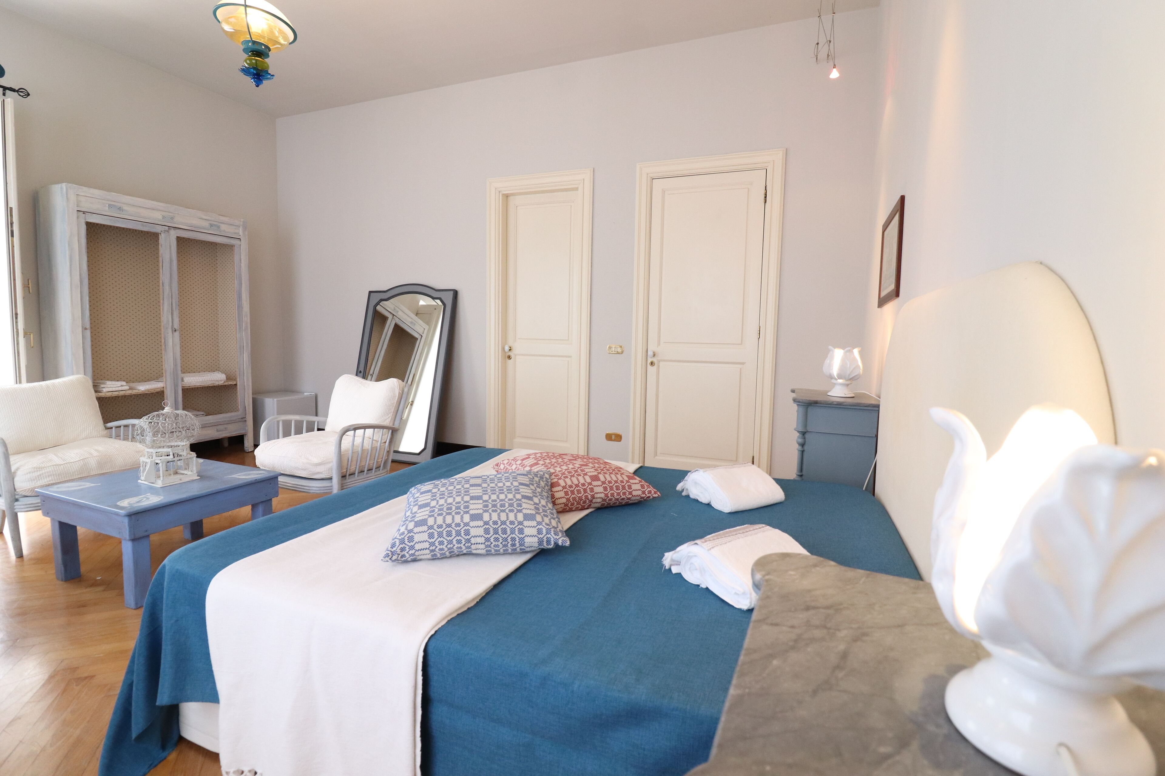 A bedroom with a bed, a nightstand, a dresser, a chair, and a mirror.