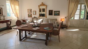 A spacious room with a wooden dining table, a sofa, and a large mirror on the wall. - Relais Delle Rose - Mimmi Executive Suite (Lecce)